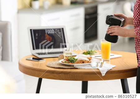 Food blogger taking photo of her lunch at wooden table indoors, closeup Food blogger taking photo of her lunch at wooden table indoors, closeup 86310527
