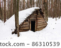 Wooden hut in the forest. Abandoned building made of logs in the snow. Russia 86310539