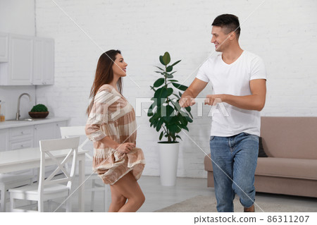 Happy young couple dancing together at home 86311207