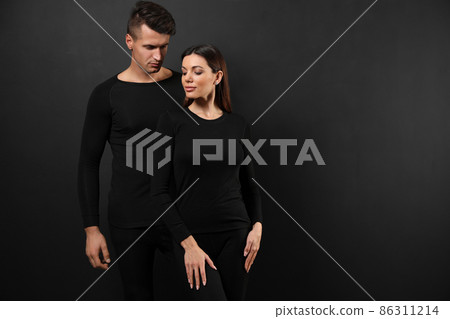 Couple wearing thermal underwear on black background. Space for text Couple wearing thermal underwear on black background. Space for text 86311214