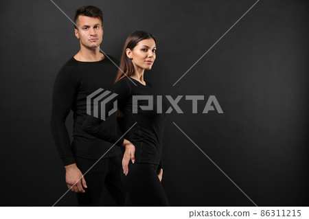 Couple wearing thermal underwear on black background. Space for text Couple wearing thermal underwear on black background. Space for text 86311215