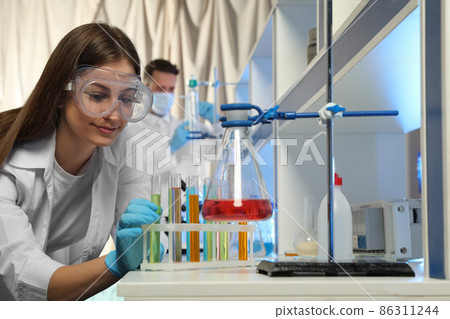 Scientist taking test tube from rack indoors. Laboratory analysis 86311244