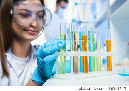Scientist taking test tube from rack indoors. Laboratory analysis 86311245