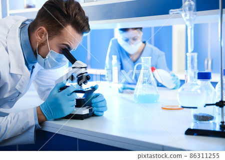 Scientist working with microscope indoors. Laboratory analysis Scientist working with microscope indoors. Laboratory analysis 86311255
