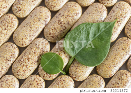 Pattern of organic herbal pills and Fresh leafs for healthy eating in daily life. 86311872