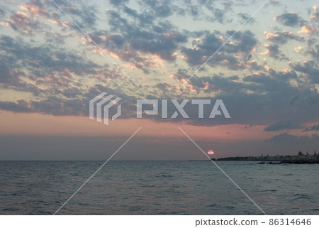 Sunrise over the sea in Kokkini Hani, Crete, Greece. Scenic seaside landscape in the cloudy morning. 86314646