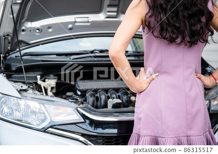 Asian trying to fix her broken vehicle. Asian trying to fix her broken vehicle. 86315517
