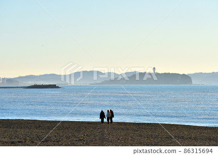 Chigasaki coast overlooking Enoshima and three women Chigasaki coast overlooking Enoshima and three women 86315694