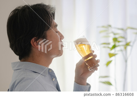 Middle man drinking beer at home 86316608