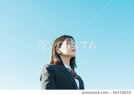 High school girl listening to music with earphones High school girl listening to music with earphones 86318650