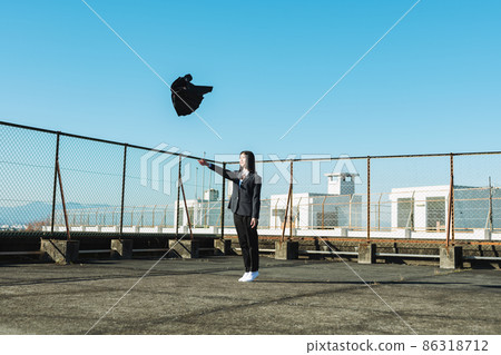 High school girl throwing a skirt on the roof of a school High school girl throwing a skirt on the roof of a school 86318712