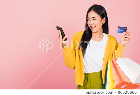 woman shopper smiling standing excited holding online shopping bags colorful and credit card 86320660