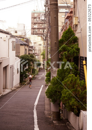 A boy practices baseball in the alley 86322673