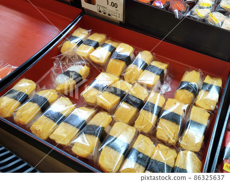 SEREMBAN, MALAYSIA - JANUARY 29, 2022: Selected focused on sushi being displayed for sale in a chiller. Separated in the tray according to type and placed a price tag for the convenience of customers. 86325637