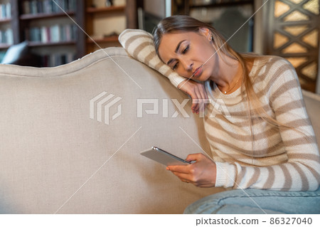 Sad lady using cellphone, looking at screen Sad lady using cellphone, looking at screen 86327040