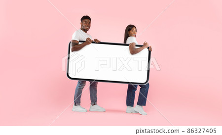 Excited black couple walking with big white empty smartphone screen 86327405
