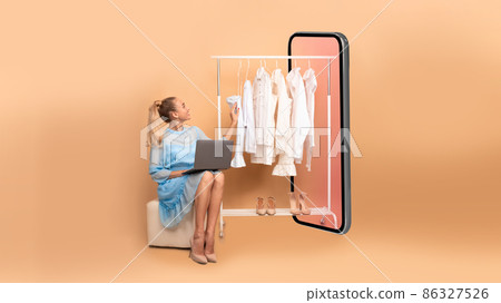 Woman Shopping Online Using Laptop Sitting Near Big Smartphone, Studio Woman Shopping Online Using Laptop Sitting Near Big Smartphone, Studio 86327526