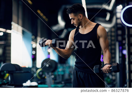 Portrait Of Young Middle Eastern Male Bodybuilder Training With Dumbbells At Gym Portrait Of Young Middle Eastern Male Bodybuilder Training With Dumbbells At Gym 86327876
