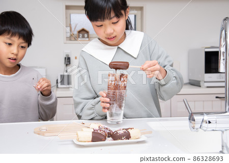 Children making chocolate bananas by hand 86328693