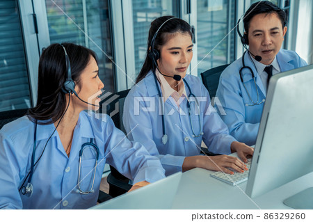 Doctor team wearing headset talking actively on video call in hospital clinic Doctor team wearing headset talking actively on video call in hospital clinic 86329260