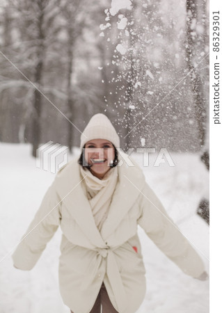 Two girls playing snowballs in the snow in the winter in a warm winter clothes 86329301