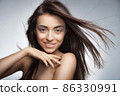 Attractive smiling woman with long hair on grey 86330991