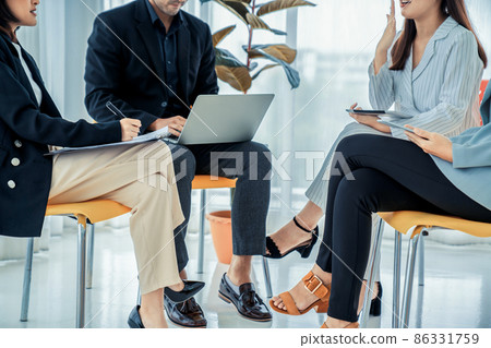 Business people proficiently discuss work project while sitting in circle 86331759
