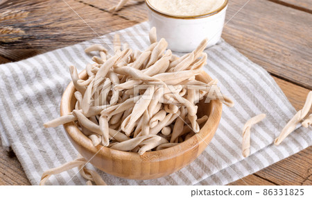 Whole grain wheat apulian pasta called Pizzarieddi or maccaruni on wooden table. Italian homemade pasta background Whole grain wheat apulian pasta called Pizzarieddi or maccaruni on wooden table. Italian homemade pasta background 86331825