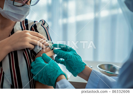 Young woman visits skillful doctor at hospital for vaccination 86332606