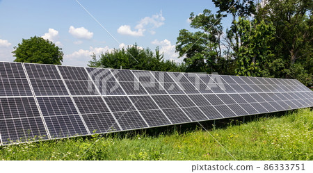 solar panels installed on the ground produce environmentally friendly energy in summer 86333751