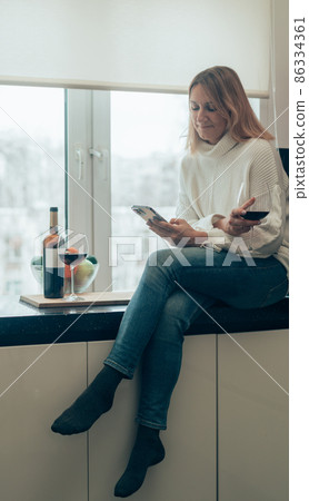 woman with wine and smartphone woman with wine and smartphone 86334361