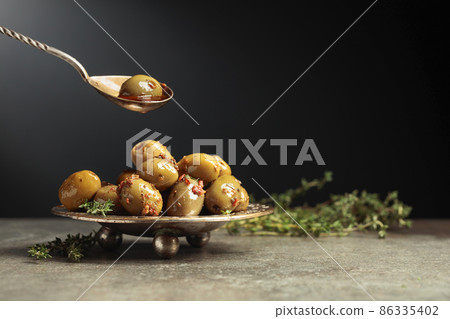 Spicy green olives are poured with olive oil with spices. Spicy green olives are poured with olive oil with spices. 86335402