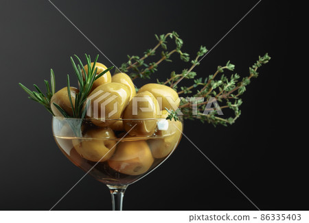 Green olives with rosemary and thyme. 86335403