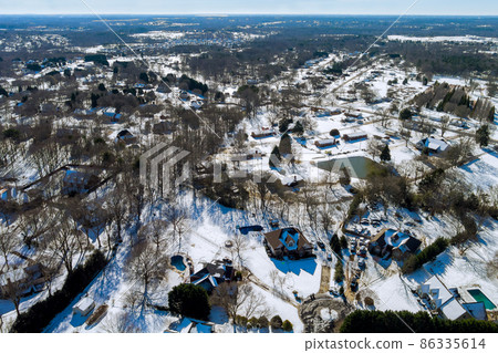 Aerial view of snowed in traditional housing estate the suburbs in dangerous weather conditions 86335614