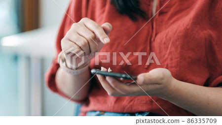 Close up woman using smart phone with hand finger touch screen, texting, chatting or social media Close up woman using smart phone with hand finger touch screen, texting, chatting or social media 86335709
