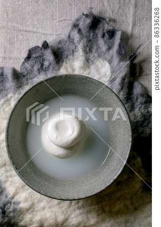 Traditional italian burrata knotted cheese in bowl 86336268