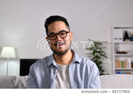 Portrait shot of happy friendly and confident Asian businessman making video call Portrait shot of happy friendly and confident Asian businessman making video call 86337868