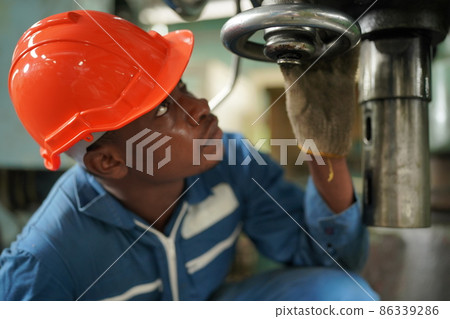 African American lathe worker working with milling machine in metal industry. 86339286