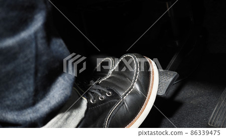 Accelerate and Brake. Foot pressing foot pedal of a car to drive ahead. Accelerator and brake pedal in a car. Driver driving the car by pushing accelerator pedals of the car. inside vehicle automobile 86339475