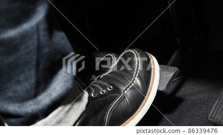 Accelerate and Brake. Foot pressing foot pedal of a car to drive ahead. Accelerator and brake pedal in a car. Driver driving the car by pushing accelerator pedals of the car. inside vehicle automobile 86339476