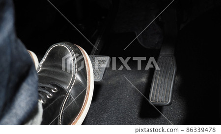 Accelerate and Brake. Foot pressing foot pedal of a car to drive ahead. Accelerator and brake pedal in a car. Driver driving the car by pushing accelerator pedals of the car. inside vehicle automobile 86339478