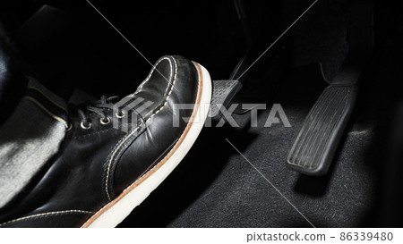Accelerate and Brake. Foot pressing foot pedal of a car to drive ahead. Accelerator and brake pedal in a car. Driver driving the car by pushing accelerator pedals of the car. inside vehicle automobile 86339480