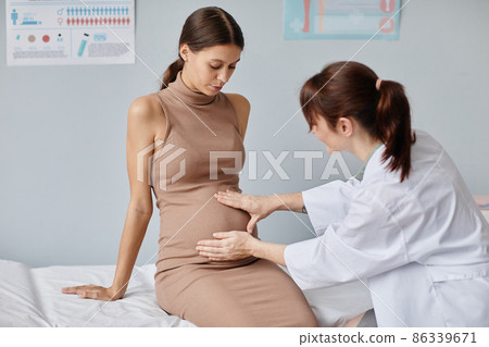 Doctor examining the pregnant woman 86339671