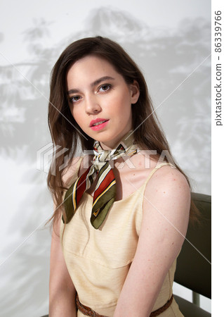 Young woman in beige dress with shadow behind Young woman in beige dress with shadow behind 86339766