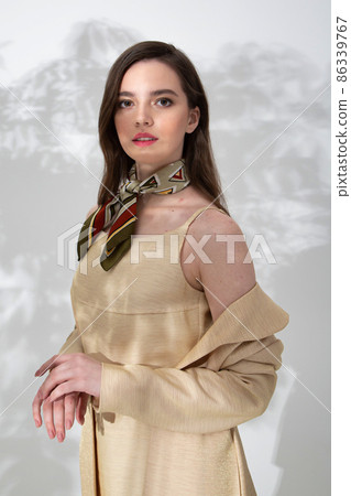 Young woman in beige dress with shadow behind Young woman in beige dress with shadow behind 86339767