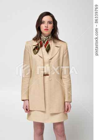 Young woman in beige suit isolated on light grey Young woman in beige suit isolated on light grey 86339769
