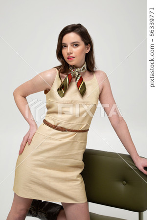 Young woman in beige dress isolated on light grey Young woman in beige dress isolated on light grey 86339771