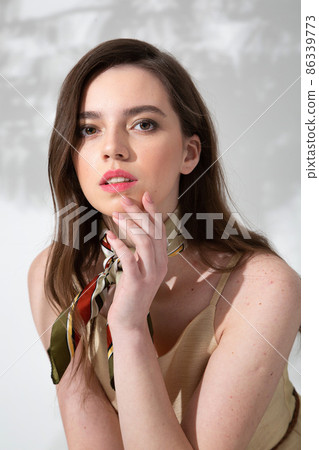 Young woman in beige dress with shadow behind Young woman in beige dress with shadow behind 86339773