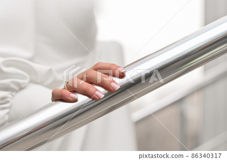 girl's hand on the metal railing. beautiful fingers with manicure and ring 86340317