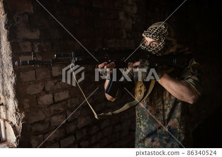 Arab soldier aiming with Kalashnikov AK-47 assault rifle 86340524